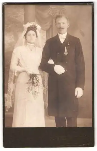 Fotografie Th. Wenzel, Berlin, Herr im Anzug mit Orden Eisernes Kreuz am Band und Braut, Kriegstrauung