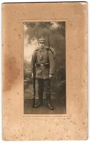 Fotografie unbekannter Fotograf und Ort, Soldat in Feldgrau Uniform mit Pickelhaube Tarnbezug, Bajonett auf Gewehr