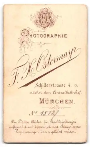 Fotografie F. H. Ostermayr, München, Soldat in Uniform nebst Raupenhelm auf dem Tisch