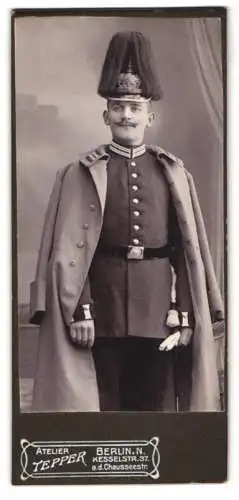 Fotografie Atelier Tepper, Berlin, Soldat in Garde Uniform mit Pickelhaube Rosshaarbusch und Uniformsmantel