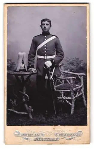 Fotografie Jos. Stegmann, Mülhausen i. E., Soldat in Uniform mit Pickelhaube Rosshaarbusch und Säbel