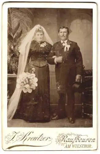 Fotografie J. Kreutzer, Kaufbeuren, Hochzeitspaar im schwarzen Brautkleid und Anzug mit Zylinder