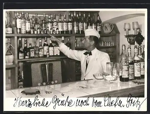 Foto-AK Gastwirt hinter der Bar, auf einen Schnaps deutend