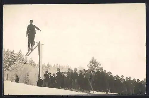 Foto-AK Skispringer beim Sprung vor Publikum, österr. Fahne