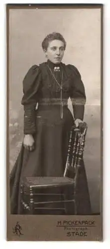 Fotografie H. Pickenpack, Stade, Frau mit Stuhl in elegantem Kleid