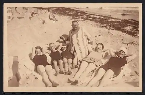 Foto-AK Timmendorferstrand, Entspannte Gruppe in Badeanzügen im Sand am Meer