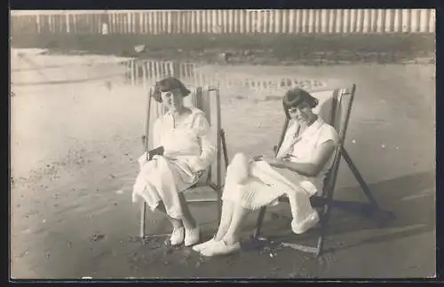 Foto-AK Zwei junge Damen in Strandkleidern auf Liegestühlen am Wasser