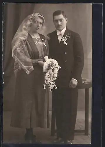 Foto-AK Braut im dunklen Kleid mit Bouquet neben ihrem Bräutigam im Anzug, Hochzeit