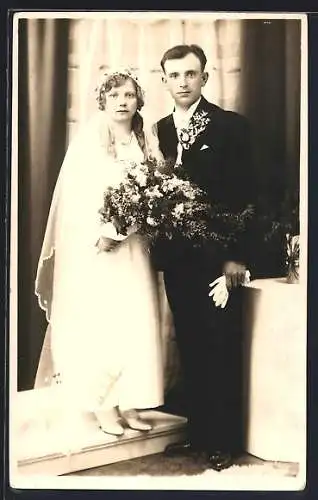 Foto-AK Braut im weissen Kleid mit Bouquet neben ihrem Bräutigam im Anzug, Hochzeit