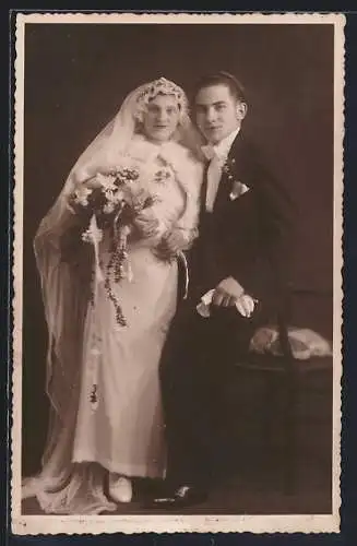 Foto-AK Braut im weissen Kleid mit Bouquet neben ihrem Bräutigam im Anzug, Hochzeit