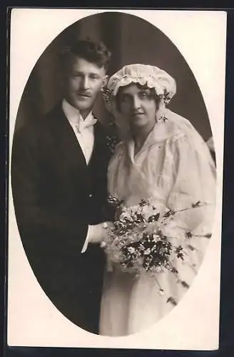 Foto-AK Braut im weissen Kleid mit Blumenbouquet neben ihrem Bräutigam im Anzug, Hochzeit