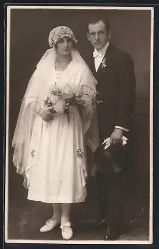 Foto-AK Braut im weissen Kleid mit Schleier und Bouquet neben ihrem Bräutigam im Anzug, Hochzeit