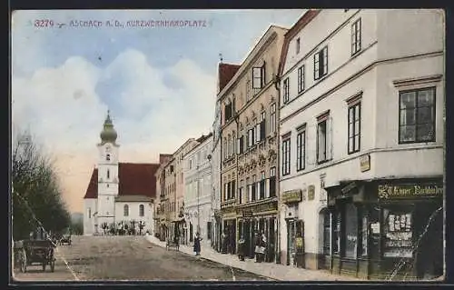 AK Aschach a. D., Kurzwernhardplatz mit Geschäften und Blick zur Kirche