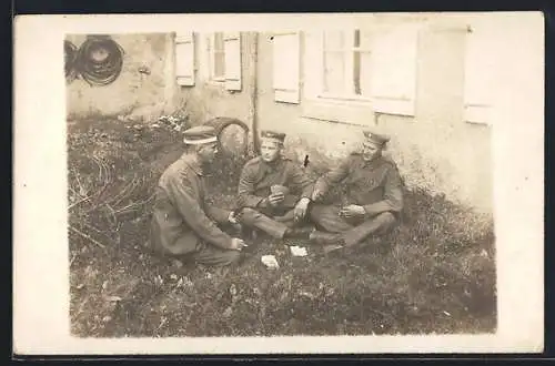 Foto-AK Drei junge Soldaten beim Kartenspiel vor einem Haus