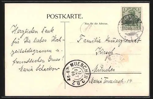 AK Amor fährt mit Herz und Blumenstrauss eine Strasse entlang