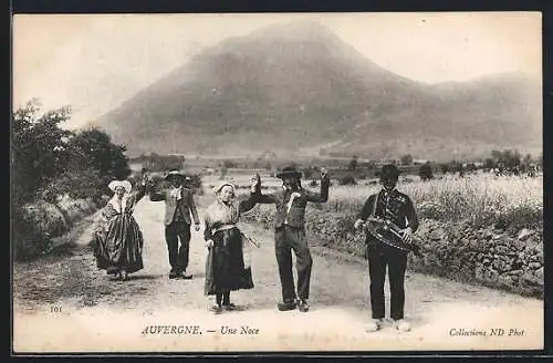 AK Auvergne, Trachtengruppe mit Drehleier vor Bergpanorama