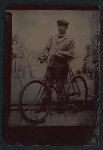 Fotografie Ferrotypie Mann im Anzug mit seinem Fahrrad samt Karbidlampe vor einer Studiokulisse