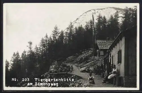 AK Tiergartenhütte am Simonyweg, Leute davor auf Bank und an Tischen