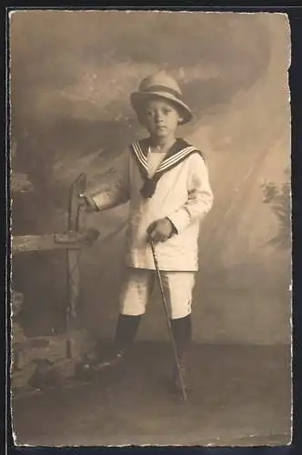 Foto-AK Kleiner Junge im Matrosenkragen vor einer Studiokulisse