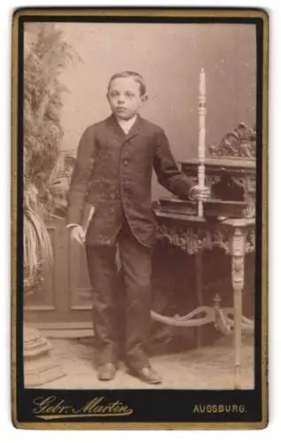 Fotografie Gebr. Martin, Augsburg, Bahnhofstrasse, Junge mit Buch und Kerzenhalter