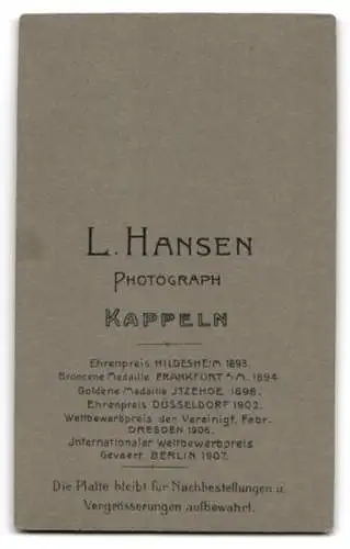 Fotografie L. Hansen, Kappeln, Kleines Kind in weissem Kleid auf Fellunterlage