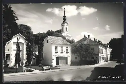 AK Gr. Siegharts /N.-Ö., Strassenpartie mit Kleidergeschäft u. Kirchturm