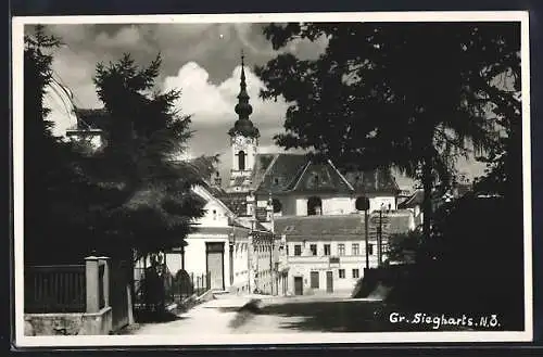 AK Gr. Siegharts /N.-Ö., Strassenpartie mit Blick auf Haus B. Schiefer und Kirche