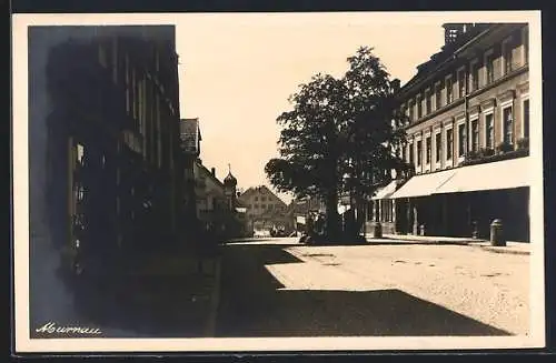 AK Murnau / Obb., Strassenpartie mit Kirche bei Sonnenschein