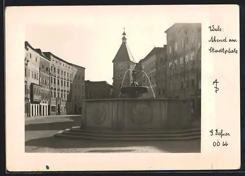 Foto-AK Adalbert Defner: Wels, Abend am Stadtplatz mit Brunnen