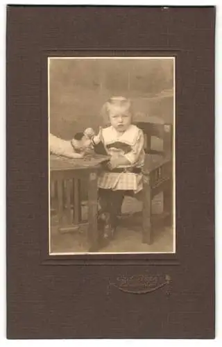 Fotografie Carl Thiel, Nordhausen, Breite Str. 3, Kleinkind mit Spielzeughund und Puppe in den Händen