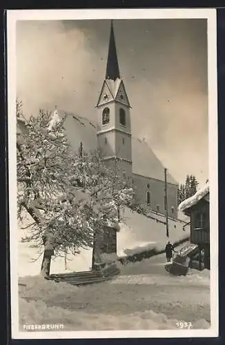 AK Fieberbrunn, Blick auf eine Kirche im Winter