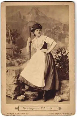 Fotografie von Ney, Berchtesgaden, junge Frau in bayrischer Tracht mit Wanderstock vor einer Studiokulisse