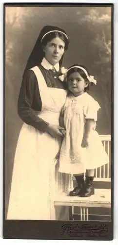 Fotografie Friedr. Fennekohl, Geestemünde, Krankenschwester im Schwesterndress mit jungem Schützling