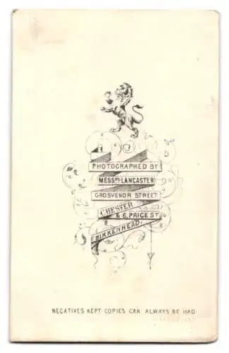 Fotografie Messrs. Lancaster, Chester, Grosvenor Street, Herr im Anzug neben Tisch