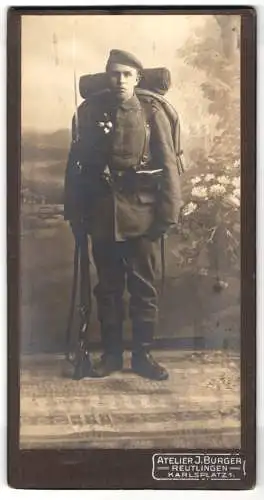 Fotografie J. Burger, Reutlingen, junger Soldat zum Kriegsausmarsch mit Marschgepäck, Bajonet auf Gewehr