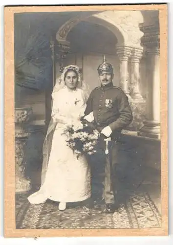 Fotografie Fotograf und Ort unbekannt, Soldat in Uniform mit Orden und Pickelhaube bei seiner Trauung, Kriegshochzeit