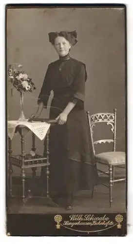 Fotografie Wilh. Schwabe, Sangerhausen, Bahnhofstr, Frau im dunklen Kleid mit Blumenarrangement