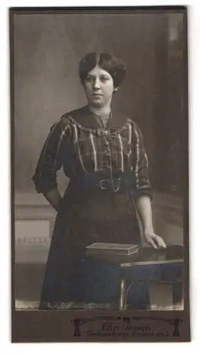 Fotografie Chr. Jessen, Delmenhorst, Louisenstr. 3, Frau in kariertem Kleid an Tisch