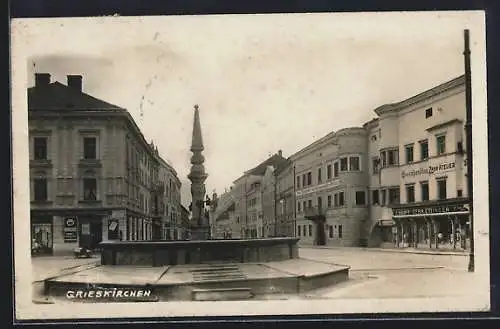 AK Grieskirchen, Strassenpartie mit Geschäften und Brunnen