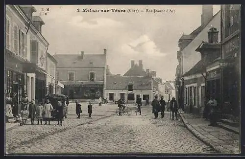 AK Mehun-sur-Yèvre, Rue Jeanne d`Arc avec passants et cycliste sur la place centrale