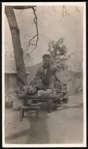 Fotografie Chinesischer Priester beim Mittagessen, Teekanne und Pfeife, 1923