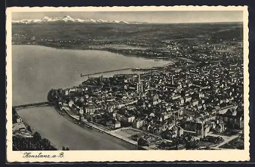 AK Konstanz /Bodensee, Ortsansicht mit See und Alpen, Fliegeraufnahme