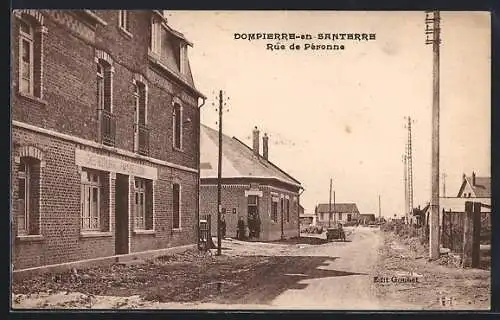 AK Dompierre-en-Santerre, Rue de Péronne avec bâtiments en briques et route animée