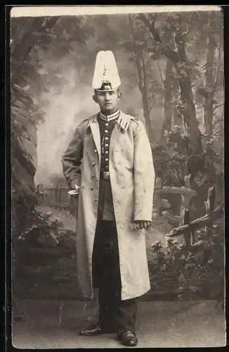 Fotografie junger Soldat in Garde Uniform mit Pickelhaube Rosshaarbusch und Mantel