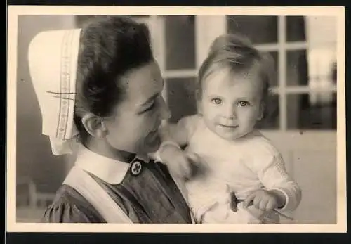 Fotografie Kinderklinik Kiel, DRK Krankenschwester mit kleiner Patientin im Arm 1952