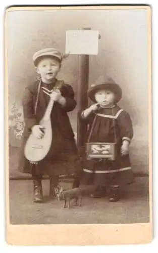 Fotografie unbekannter Fotograf und Ort, zwei niedliche Kinder mit Mandoline und Stofftier Esel
