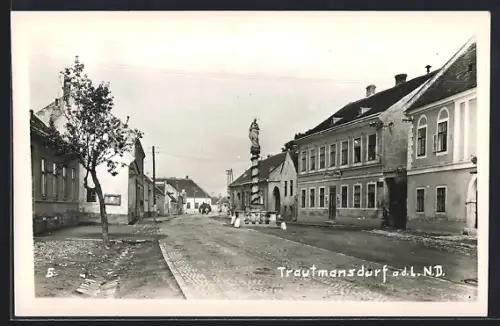 AK Trautmannsdorf a. d. L., Strassenpartie mit Denkmal