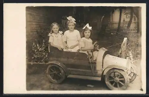Foto-AK Drei Mädchen in einem hölzernen Bollerwagen, Spielzeug