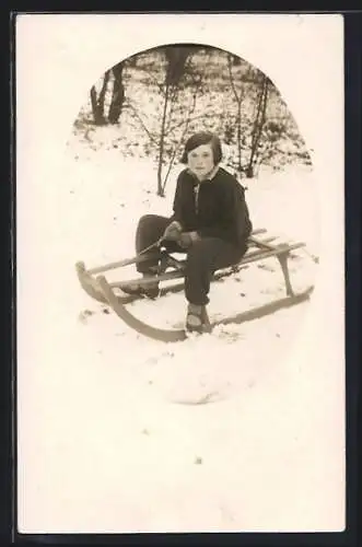 AK Mädchen auf einem Schlitten sitzend