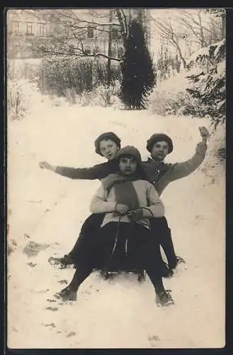 AK Drei junge Leute bei der Fahrt auf einem Schlitten